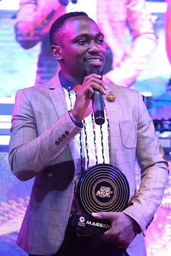 Moustey on stage holding the UG Mix Maestro award