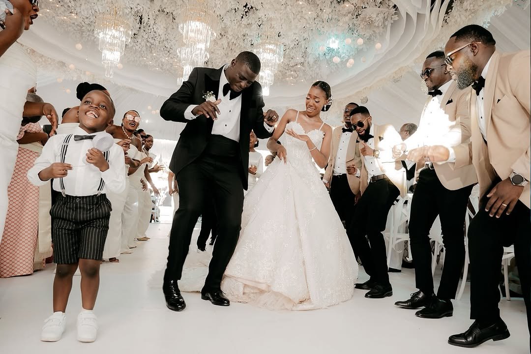 Bride and groom dancing with their groomsmen and a page boy at their reception